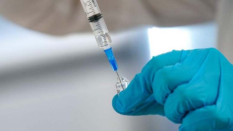 Close-up of syringe and vial used for mRNA therapy