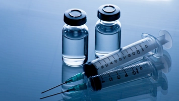 Syringes and vials representing personalized mRNA cancer vaccine research in Europe